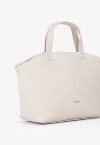 Borsa a tracolla strutturata beige realizzata in pelle testurizzata, con manici doppi arrotondati, accentuata da un dettaglio triangolare alla base e un logo sottile.