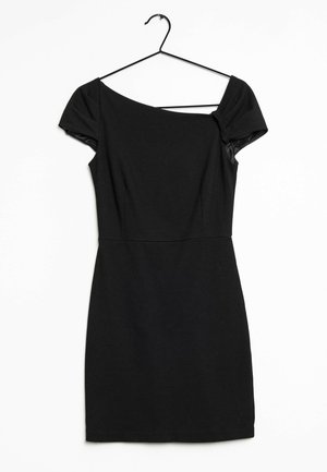 Vestido negro ajustado de manga corta con escote asimétrico colgado en una percha negra sobre un fondo blanco.