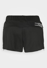 Svarta sportshorts med bred midja, dragkedjor på sidorna och varumärkestext på baksidan nära midjan.