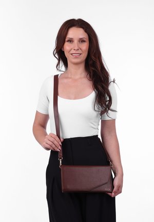Brown leather crossbody bag with a sleek, rectangular shape, gold hardware accents, and a diagonal fold detail on the front.
