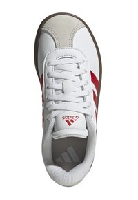 Zapatilla blanca con rayas rojas, parte superior de piel y gamuza, cordones planos, plantilla texturizada, lengüeta con marca y suela de goma marrón.