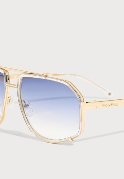 Lunettes de soleil rectangulaires à monture dorée, verres à dégradé bleu et bords intérieurs transparents, affichant le logo « DSQUARED2 » sur la branche.