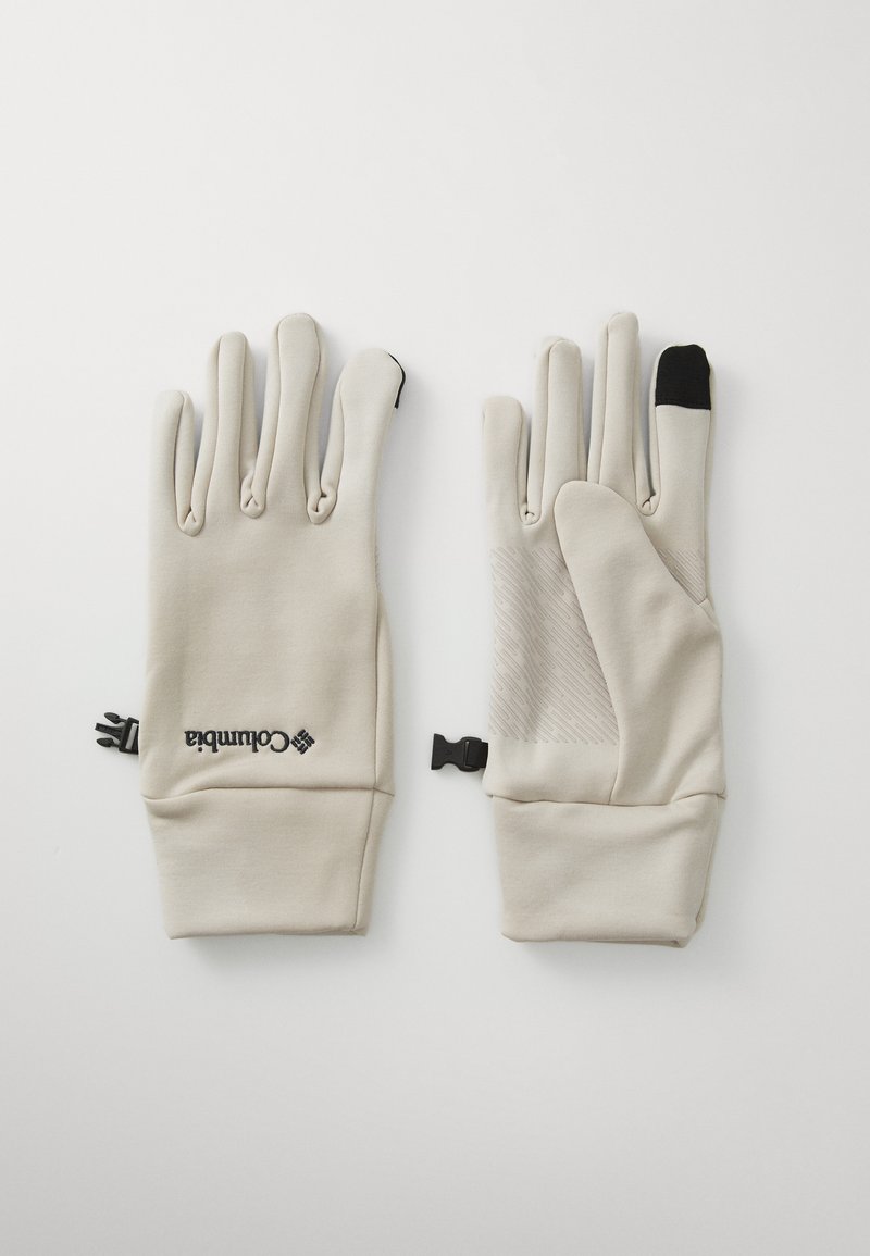 Beige käsineet, joissa on sileä pinta, mustalla peukalotipalla, kämmenen tartuntapintojen ja logon yksityiskohtia. Kiinnitysklipsi ranteessa.