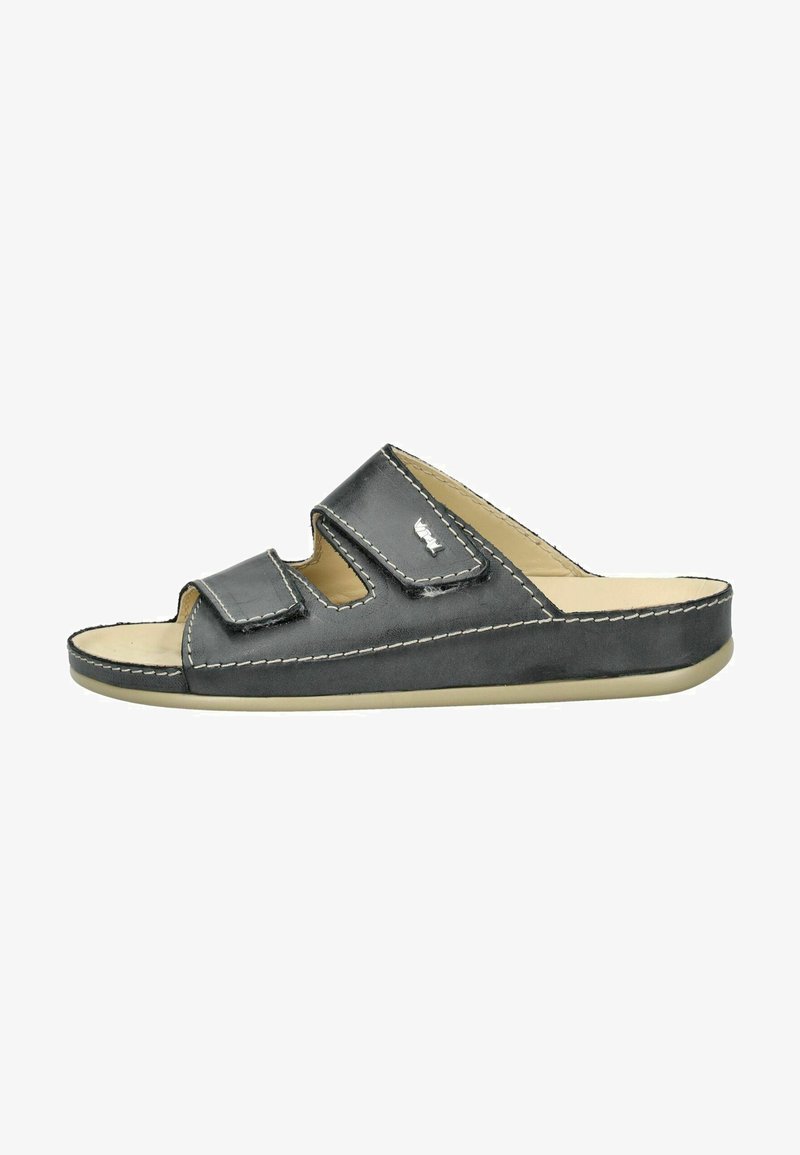 Sort lædersandal med to justerbare stropper, kontrasterende hvid syning, åben tå-design og en lav beige gummisål.