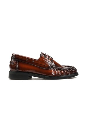 Brązowe skórzane buty typu boat shoe dla mężczyzn z czarną podeszwą, sznurowadłami i przeszyciami w stylu mokasyn na białym tle.