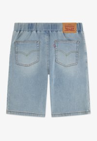 Ljusblå jeansshorts med elastisk midjeband, två bakfickor och en brun läderpatch med varumärket vid midjan.