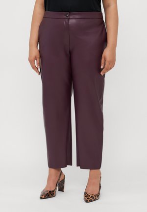 Pantaloni in finta pelle bordeaux con vita alta, chiusura frontale con bottone e gamba dritta, abbinati a scarpe con tacco alto in stampa animale.