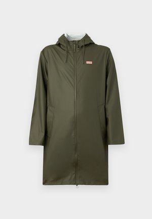 Imperméable vert olive avec capuche, fermeture éclair à l'avant et poches latérales ; présente une petite étiquette rouge sur la poitrine.