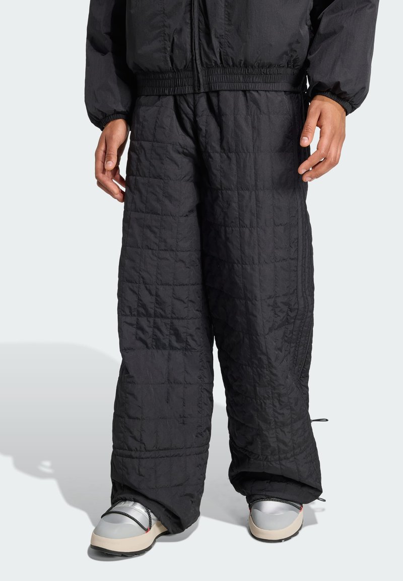 Pantalones aislantes negros con textura acolchada, cinturilla elástica y dobladillos con cordón, diseñados para comodidad y calidez.