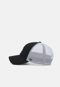 Mustan ja valkoisen värinen hattu, jossa on kiinteä musta etuosa, valkoinen verkko takana, kaareva lippa ja brodeerattu logo etupaneelissa.