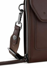 Bolso cruzado de cuero marrón con herrajes plateados, que cuenta con un cierre de cremallera y una correa ajustable con un acento decorativo.