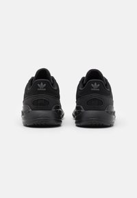 Black adidas sneakers featuring a textured mesh upper, padded collar, and rubber sole with a streamlined, rounded design.