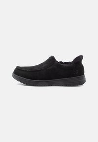 Fekete slip-on cipők puha velúrból, varrott részletekkel, párnázott belső térrel és gumitalppal a tapadás érdekében.
