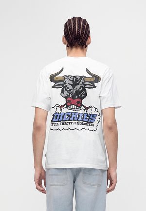 Person mit geflochtenem Haar trägt ein weißes T-Shirt mit einer Grafik eines wütenden Bullen und dem Text "Dickies Full Throttle Workwear" auf dem Rücken.