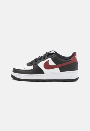 Baskets basses Nike Air Force 1 avec des panneaux et lacets noirs, blancs et rouge foncé, vues de côté sur un fond uni.