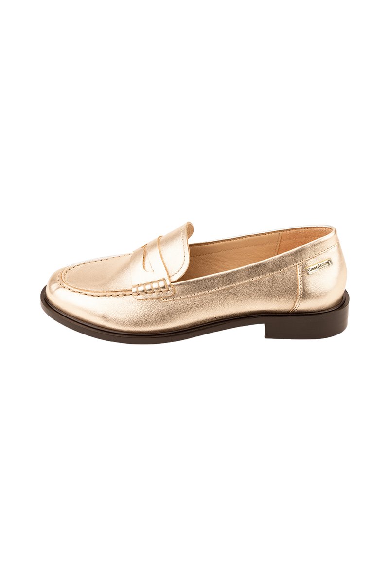 Mocassino in pelle dorata con punta arrotondata, suola piana marrone e dettagli cuciti sulla parte superiore. Presenta una piccola patta decorativa.