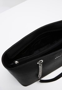 Borsa nera strutturata con texture liscia, chiusura con cerniera, tasche interne e dettaglio a catena metallica sul lato.