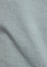 Tejido azul claro con una superficie suave y ligeramente texturizada. Presenta un patrón de finas estrías, lo que indica una suave elasticidad y comodidad.