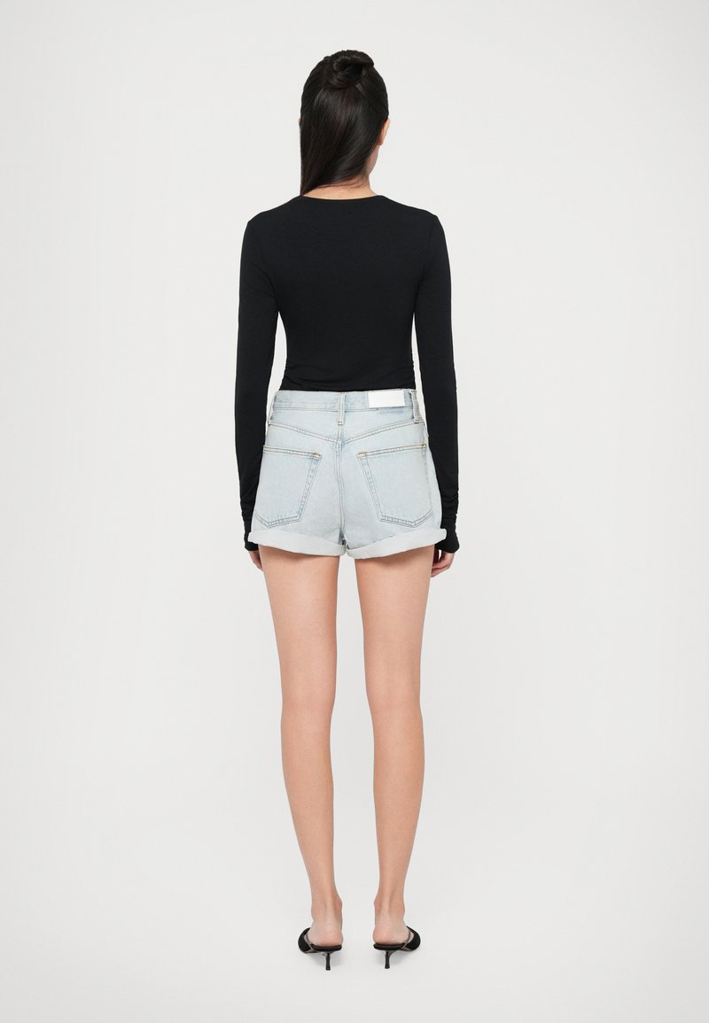Zwarte longsleeve top gecombineerd met lichtblauwe denim short met opgerolde zomen en een witte riem. Glad, aansluitend materiaal met een eenvoudig ontwerp.