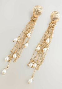 Gold-tone earrings featuring a textured oval top and dangling chains adorned with white freshwater pearls. Lengthy and elegant design.
