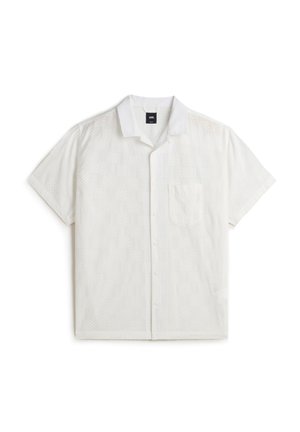 White short-sleeve shirt featuring an eyelet pattern, a notched collar, a front pocket, and button closure. Made from lightweight fabric.