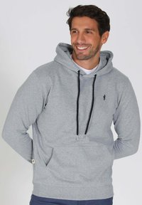 Hoodie gris clair en tissu doux, avec une poche avant, un capuchon à cordon de serrage gris foncé, et un petit logo sur la poitrine.