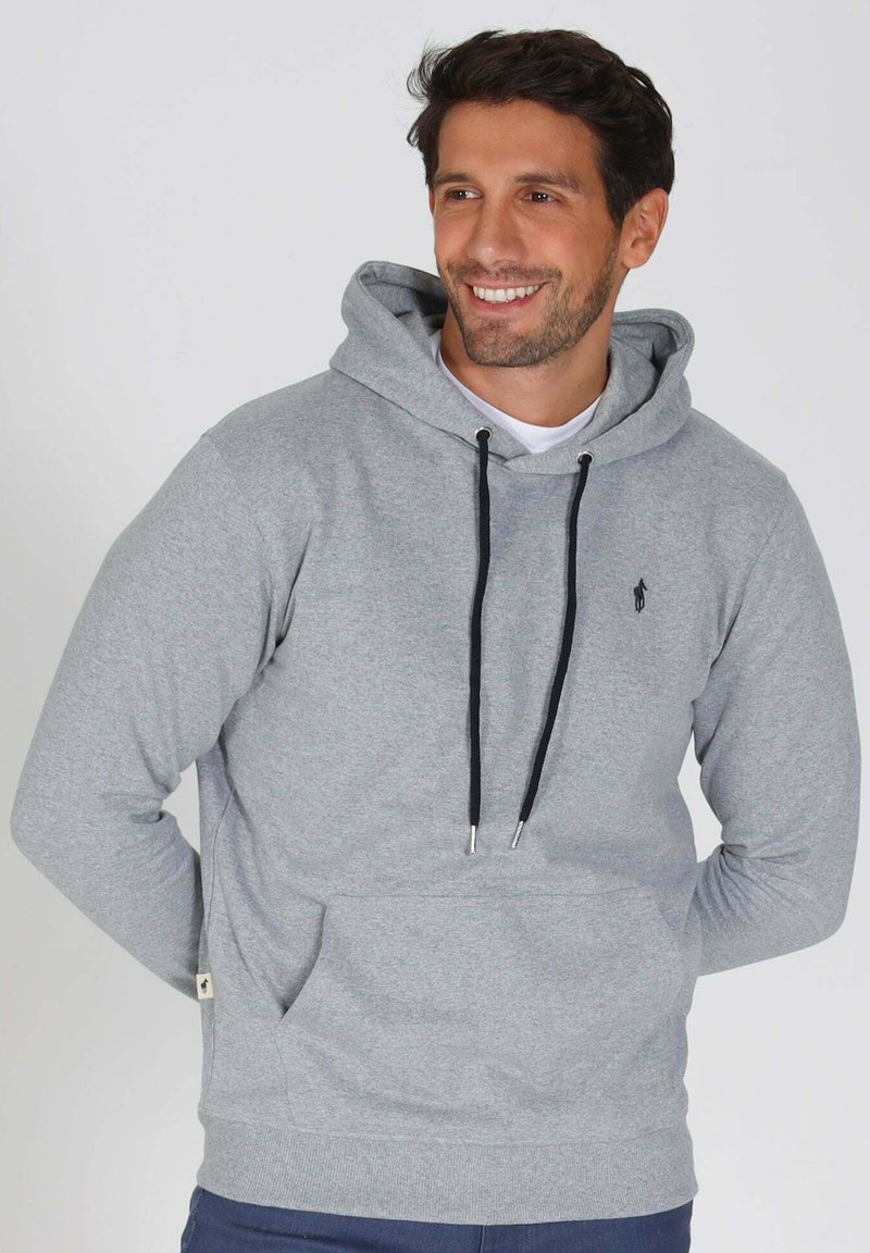 Hoodie gris clair en tissu doux, avec une poche avant, un capuchon à cordon de serrage gris foncé, et un petit logo sur la poitrine.