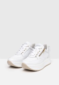 Hvide læder platform sneakers med guld hardware accenter, snørebånd og en side lynlås. Tykk hvid sål med en beige bund for greb.