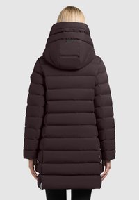 Długa, puchowa kurtka w ciemnym bordowym kolorze z wysokim kołnierzem i dużym kapturem. Posiada poziome pikowane sekcje oraz boczne kieszenie na zamek.