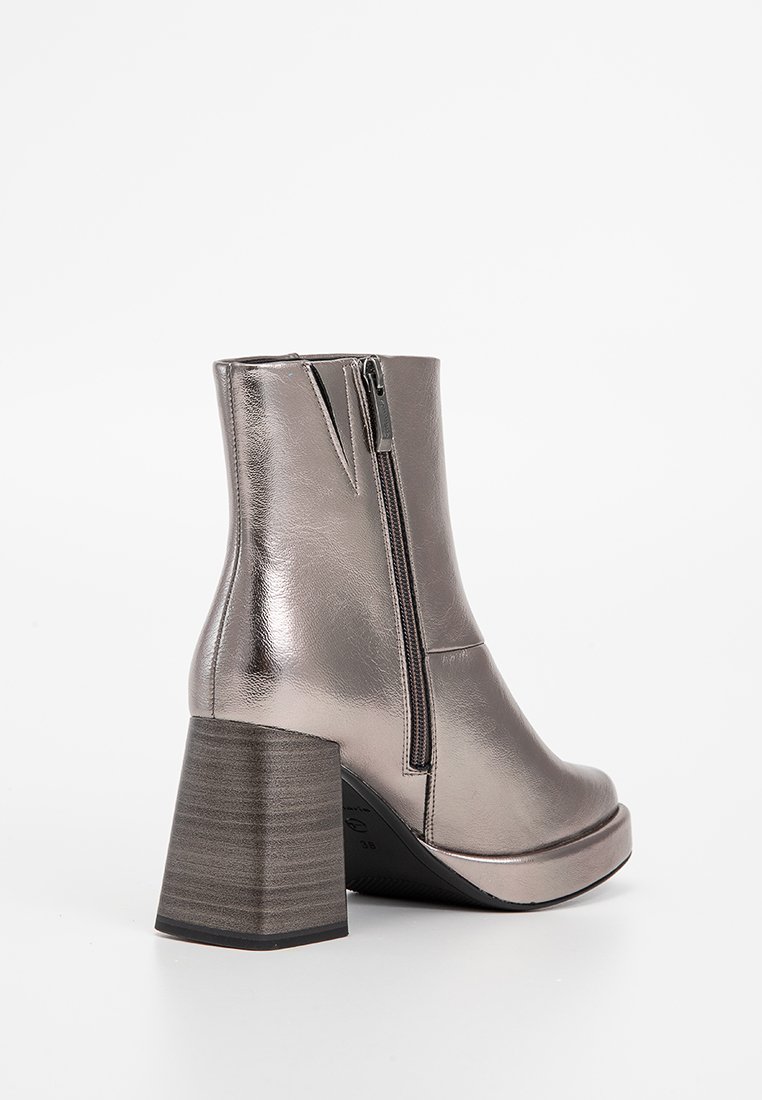 Botte de cheville grise métallique avec un talon bloc, fermeture éclair sur le côté, texture lisse et bout arrondi. Le design est élégant et moderne.