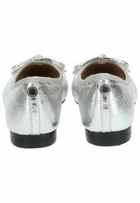 Ballerines métalliques argentées avec une finition texturée, bout rond et un nœud décoratif à l'avant. Semelle en caoutchouc noire et accent logo.