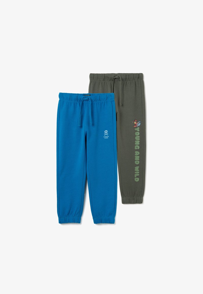 Zwei Paar Jogginghosen: eine türkisfarbene mit einem Totenkopf-Emblem, die andere olivgrün mit dem Text "YOUNG AND WILD". Beide haben elastische Bündchen und Kordelzüge.