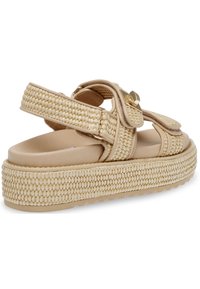 Beige Plattformsandalen mit geflochtenem Textilobermaterial, verstellbarem Riemen mit goldenen Beschlägen und strukturiertem Gummiaußenboden für besseren Halt.