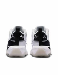 Baskets noires et blanches avec un dessus en maille texturée, un col rembourré et une semelle en caoutchouc. Présente les logos "23" et Jumpman.