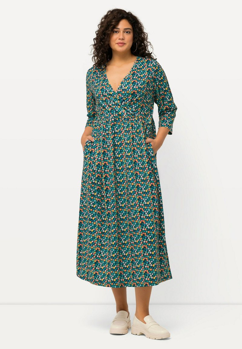 Sukienka maxi w kwiatowy wzór w odcieniu teal, ozdobiona pomarańczowymi, różowymi i żółtymi kropkami; dekolt w serek, długie rękawy, pasek w talii i kieszenie po bokach.