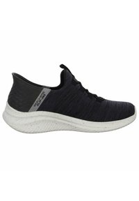 Zwarte en grijze sportieve schoenen met een gebreide bovenkant met textuur, vetersluiting en een witte gespikkelde tussenzool met een gebogen vorm.