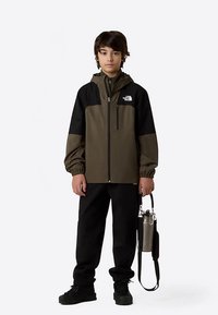 Vyrų spalvų derinimo striukė alyvuogių ir juodos spalvos, su užtrauktuku, kapišonu, elastinėmis rankovėmis ir logotipo detale. Juodos kelnes ir sidabrinę vandens butelį.