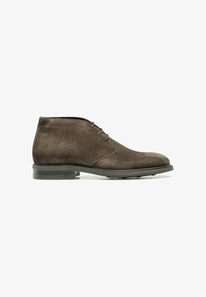 Bottes cheville en daim marron avec un bout arrondi, dotées de deux œillets pour laçage et d'une semelle texturée pour une meilleure adhérence.