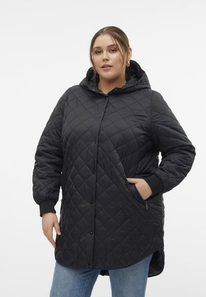 Veste noire matelassée avec capuche, dotée de fermetures à pression, de poches latérales et de poignets côtelés. Texture douce et design avec un ourlet arrière plus long.