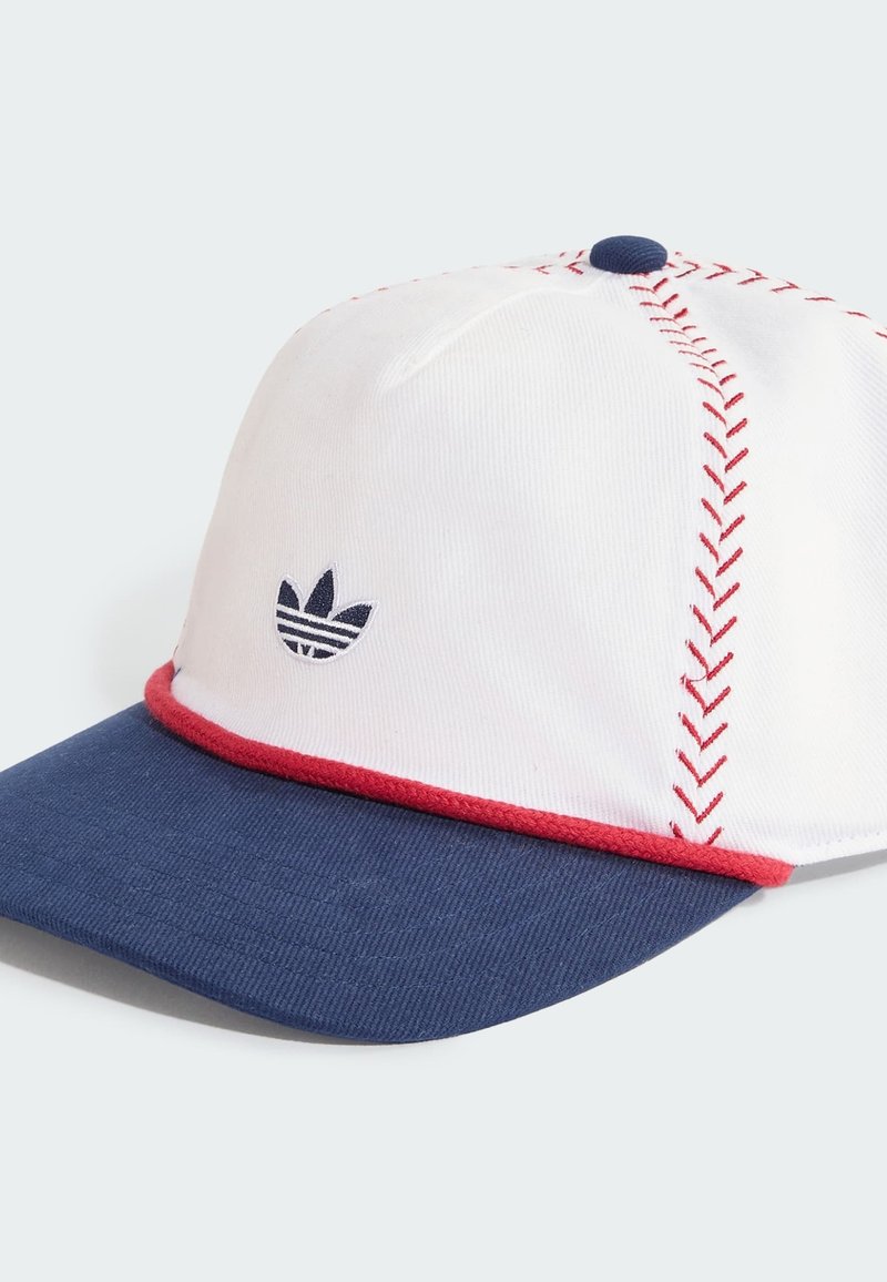 Gorra de béisbol blanca con visera azul marino, costuras rojas que imitan las costuras de béisbol y pequeño logo azul marino de Adidas en el panel frontal.