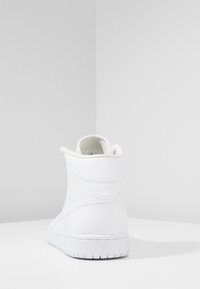 Vit hög sneakers i läder med vadderad krage, texturerade sidopaneler och gummisulor med tydligt mönster.