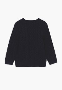 Tumma sininen neulepusero, jossa on tekstuurillinen kierreraita, pyöreä pääntie ja resorit hihansuissa. Takakatsaus tuo esiin monimutkaisen muotoilun.