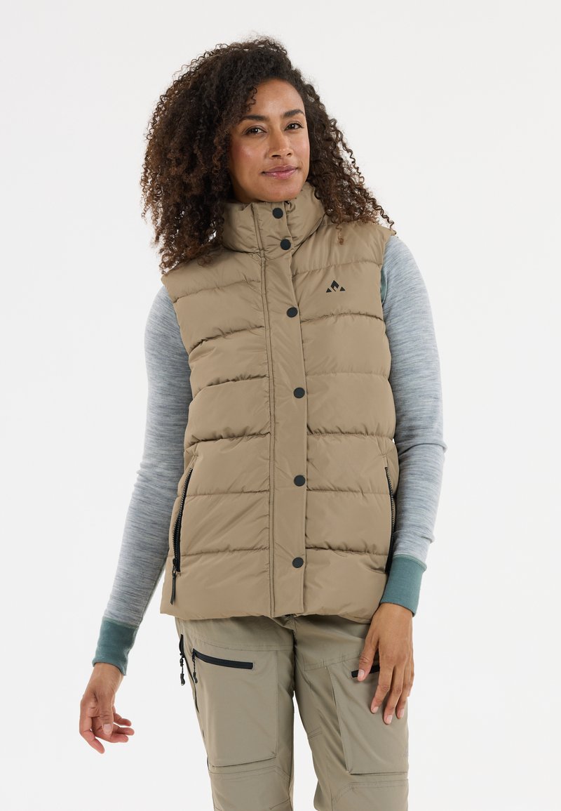 Beige Steppweste mit hohem Kragen, Knopfverschluss und seitlichen Taschen. Wird über einem hellgrauen Langarmoberteil getragen. Strukturierter Stoff mit gestepptem Design.