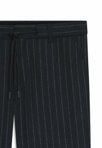 Marinrandiga byxor med dragsko i midjan, två sidofickor och fina grå ränder. Texturerad tyg med en avslappnad passform.