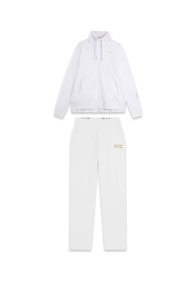 Chándal deportivo blanco que presenta una chaqueta con cremallera y un cuello alto, junto con pantalones a juego. Acentos dorados y logotipo en ambas piezas. Textura suave.