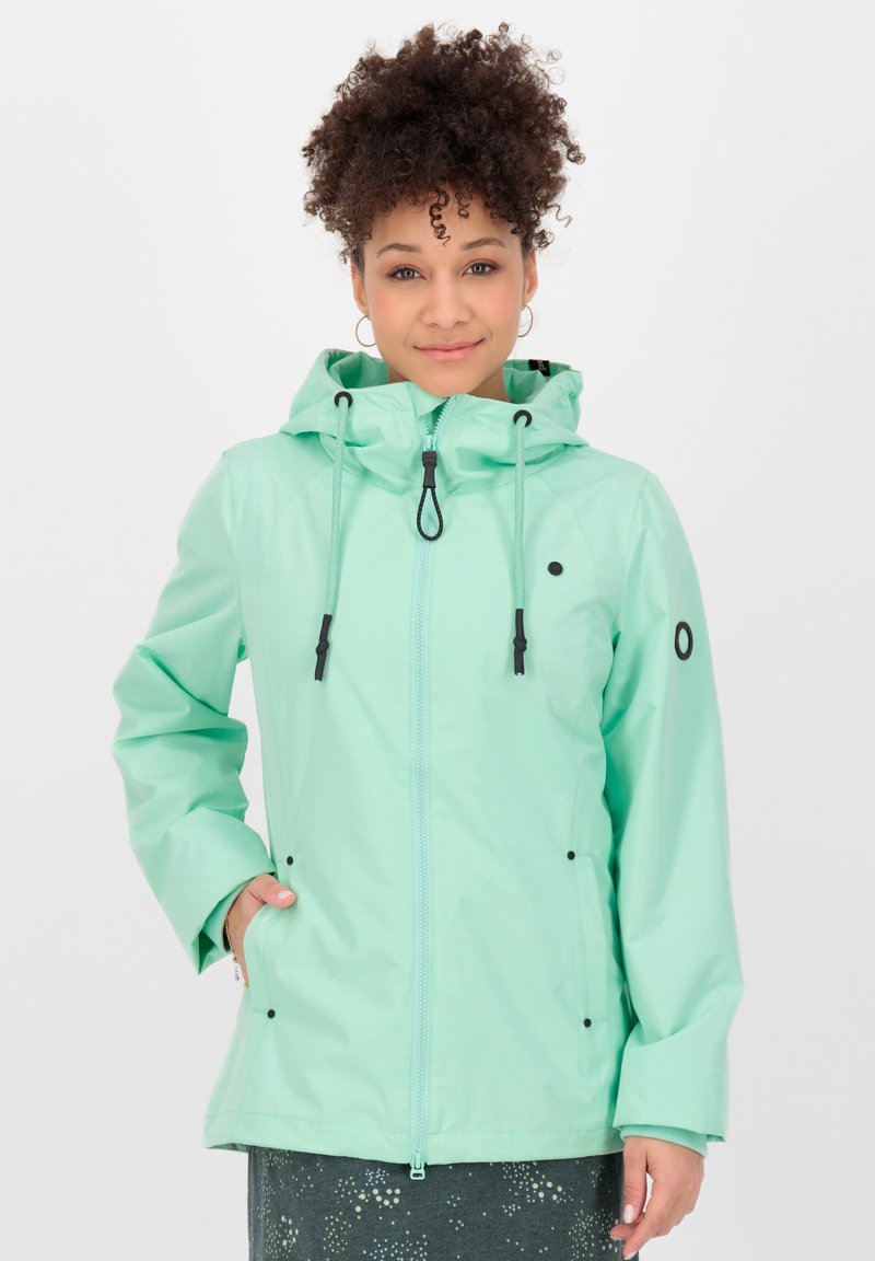 Veste imperméable vert menthe clair avec capuche, fermeture éclair avant, cordons de réglage, et accents noirs aux poches et aux poignets.