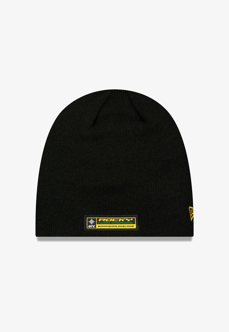 Bonnet en tricot noir à coupe ajustée, avec une étiquette carrée jaune et noire portant les textes "Rocky" et "UFC". Texture lisse.