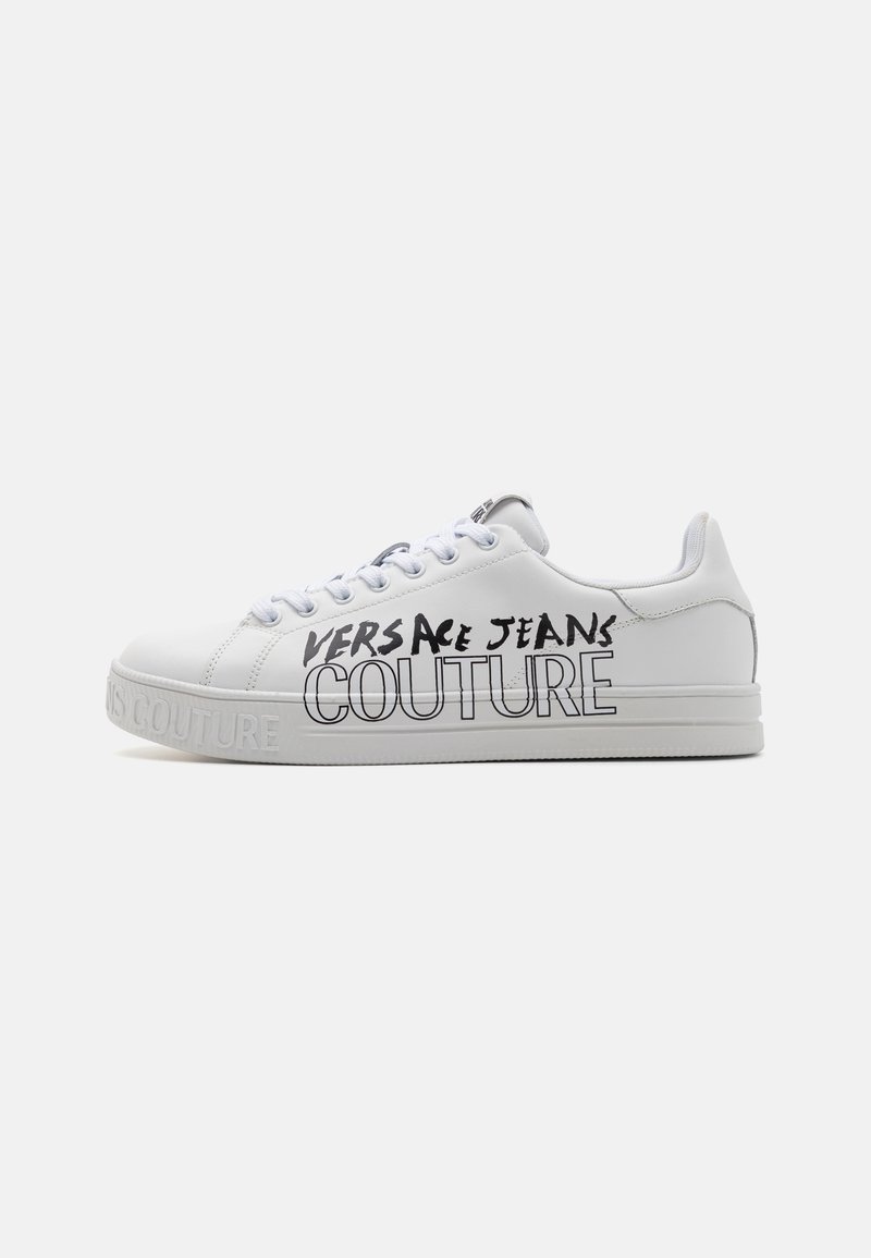 Bijela tenisica s gornjim dijelom od kože, gumeni potplat i vezanje na vezice, s crno otisnutim brandom "VERSACE JEANS COUTURE" sa strane.