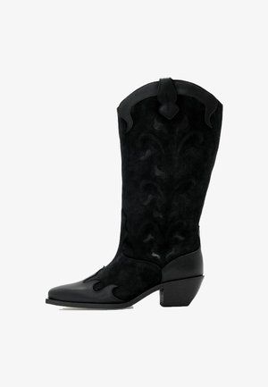 Sorte cowboystøvler lavet af ruskind med en læderhæl. Har indviklede tonale mønstre og en bred, spids tå. Kvadratisk hældesign.
