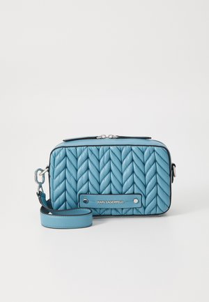 Blaue gesteppte Handtasche in rechteckiger Form, aus Leder, mit silbernem Beschlag, Markendetail auf einem schwarzen Akzent und einem verstellbaren Trageriemen.